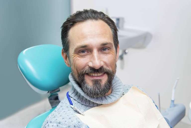 Male patient smiling in dental chair after treatment at Haley Schmitt, DDS in Brentwood TN